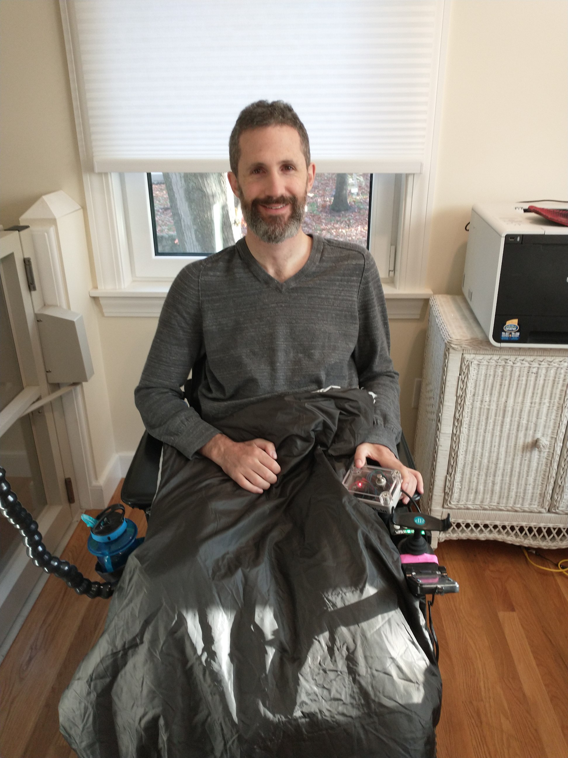 man in wheelchair with blanket on top of him