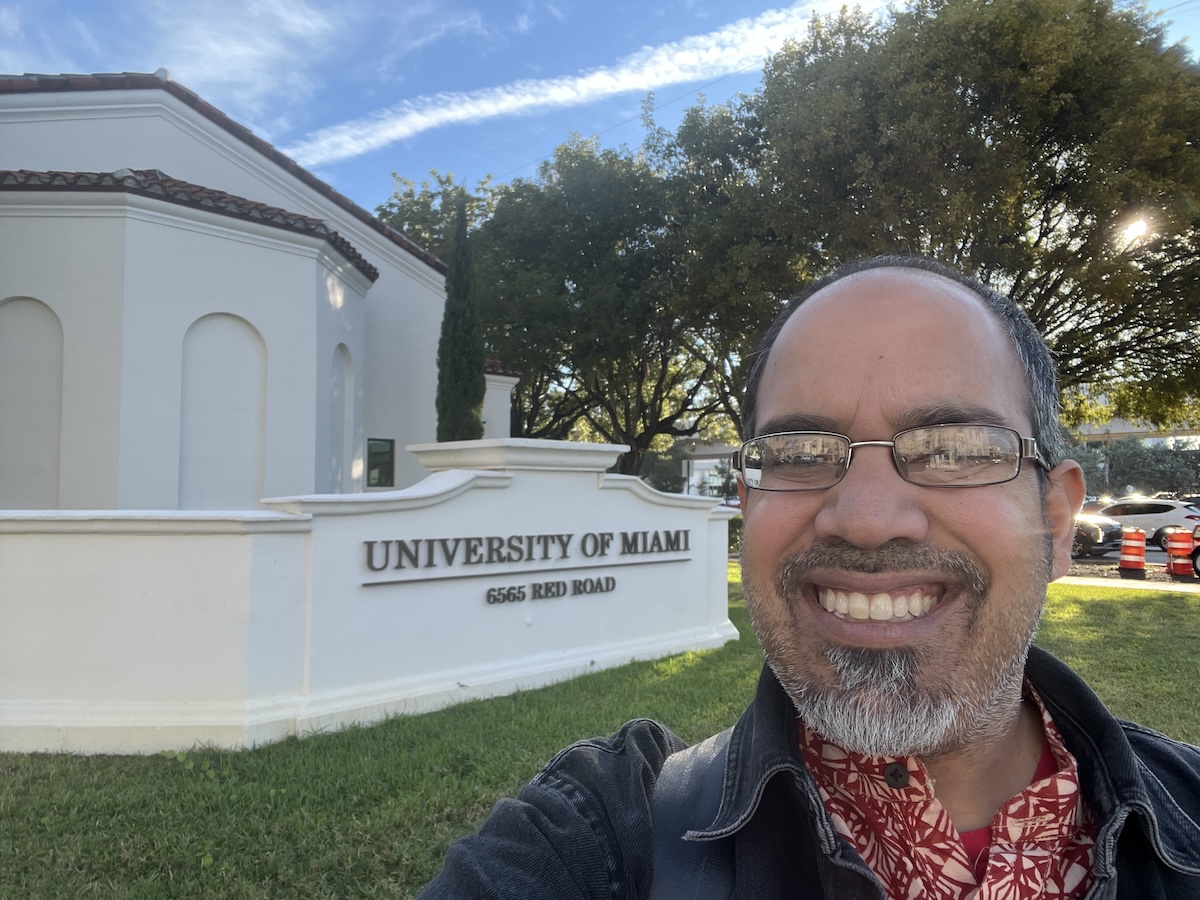 selfie of my standing outside in front of a building with signage saying "University of Miami"