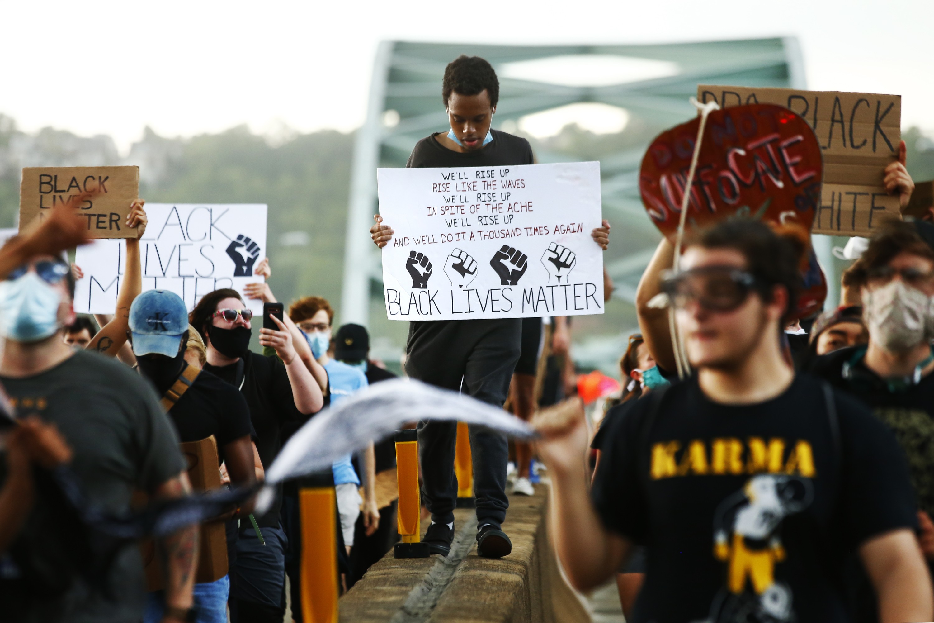 large crowd of people at a protest, holding "black lives matter" signs