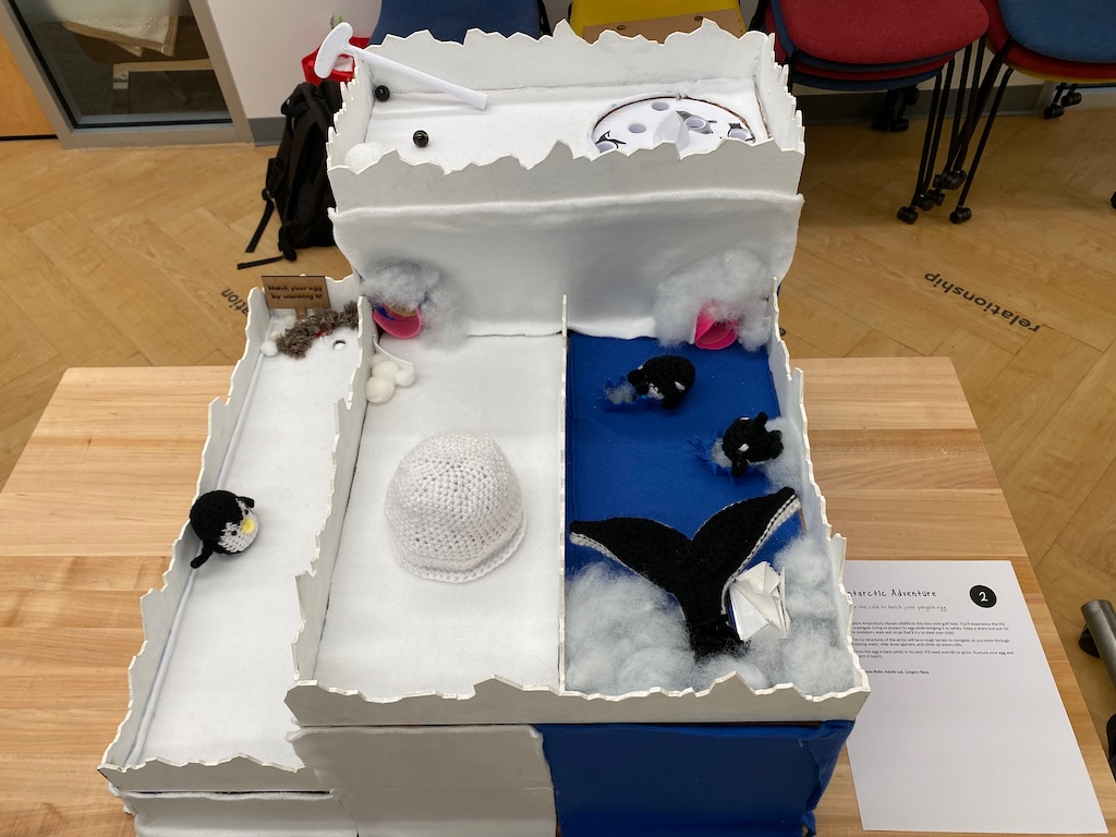 top view of mini mini golf hole colored white, with crocheted whales and an igloo obstacle