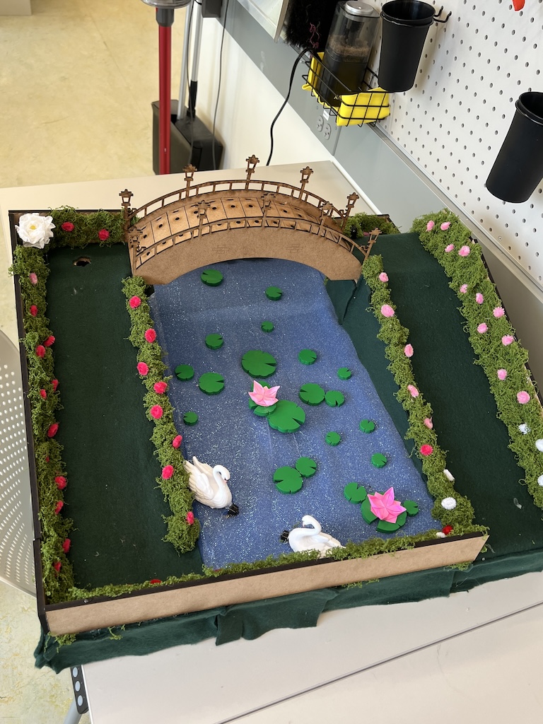 top view of mini mini golf hole colored green, with a bridge and lily pads